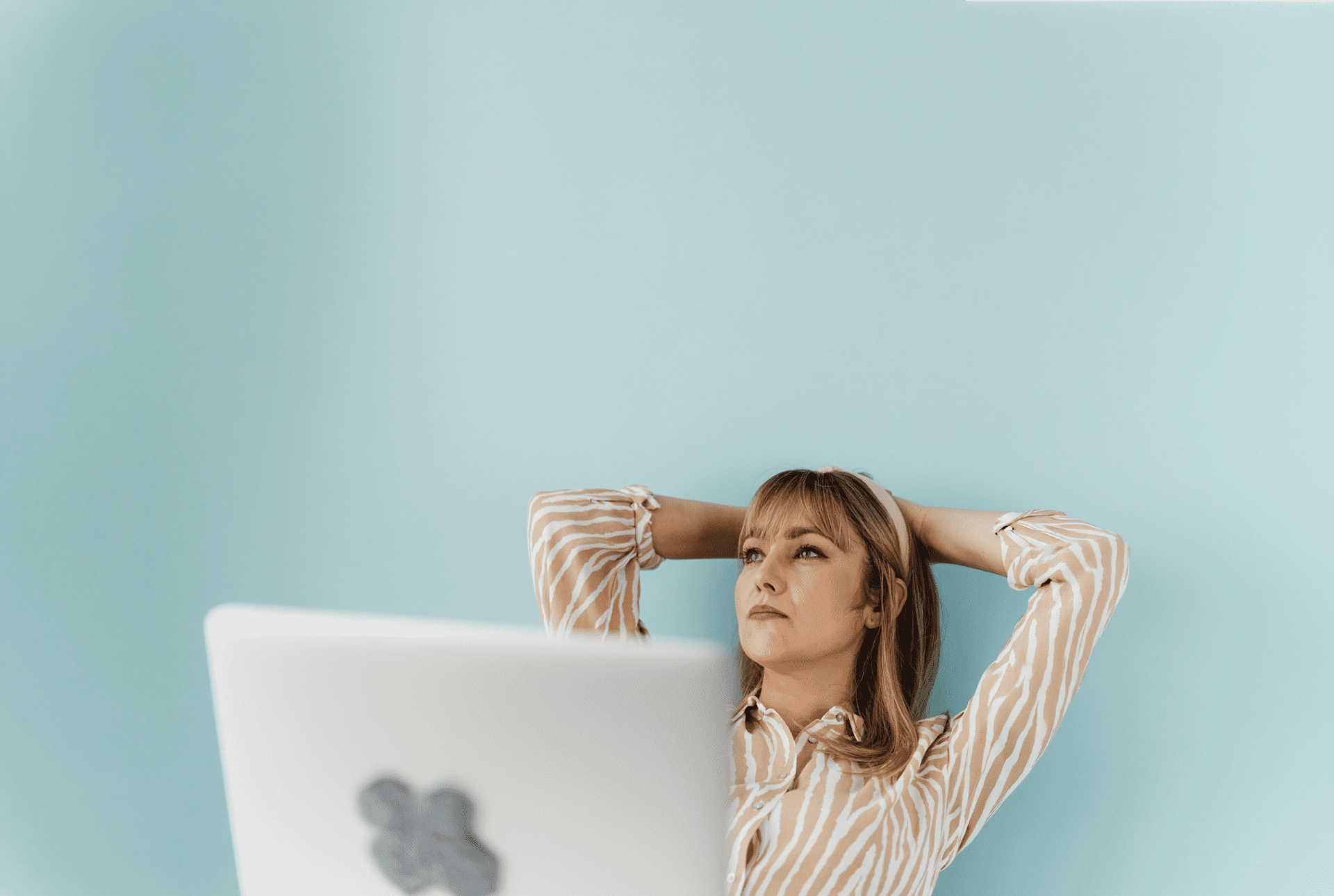 Woman leaning against a wall thinking